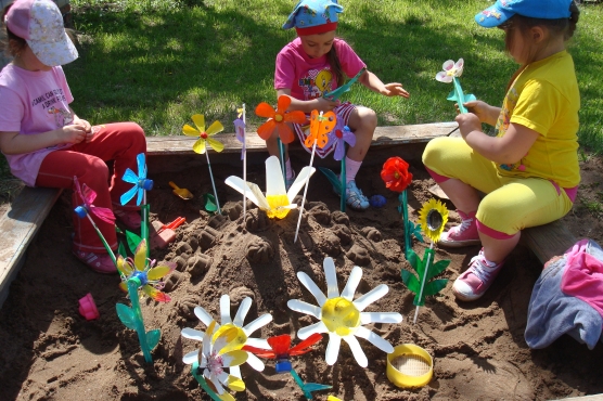 Дітям подобається створювати свої клумби граючи в піску з пластиковими квітами